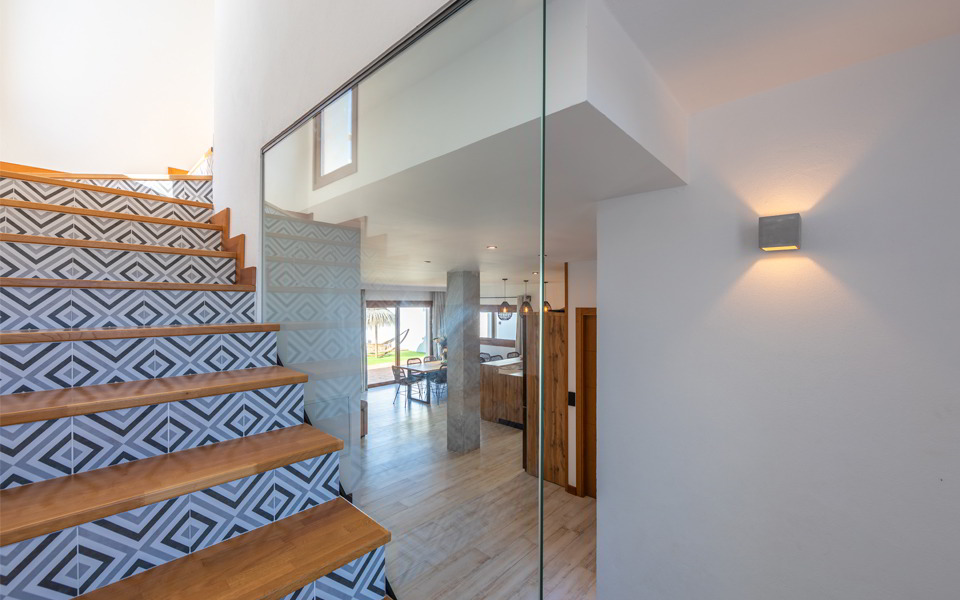 Escalera con peldaños de madera y revestimiento geométrico decorativo.