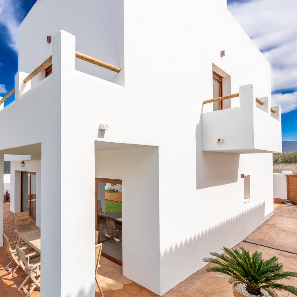 achada trasera con porche cubierto y terraza exterior privada.