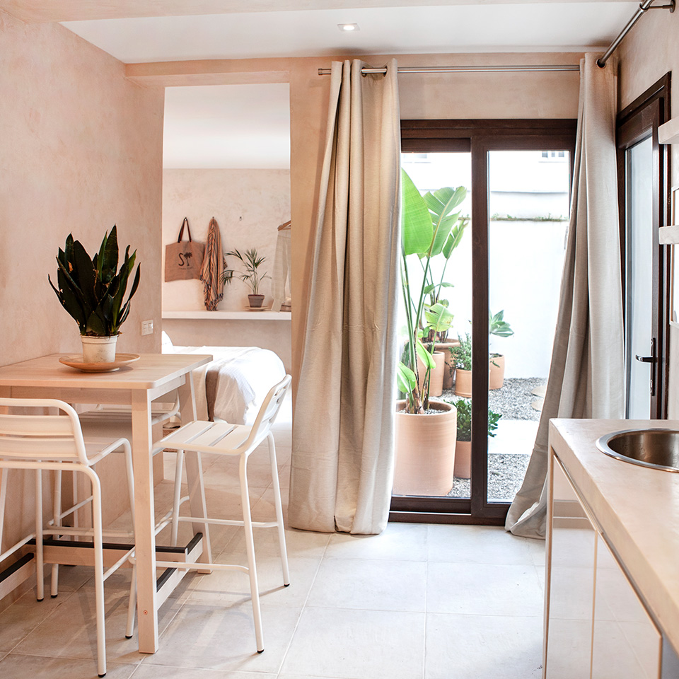 View from the kitchen of the dining room, bedroom and outdoor patio with plants