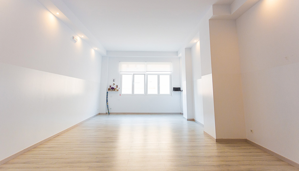 White room with bay window and soft brown wooden flooring