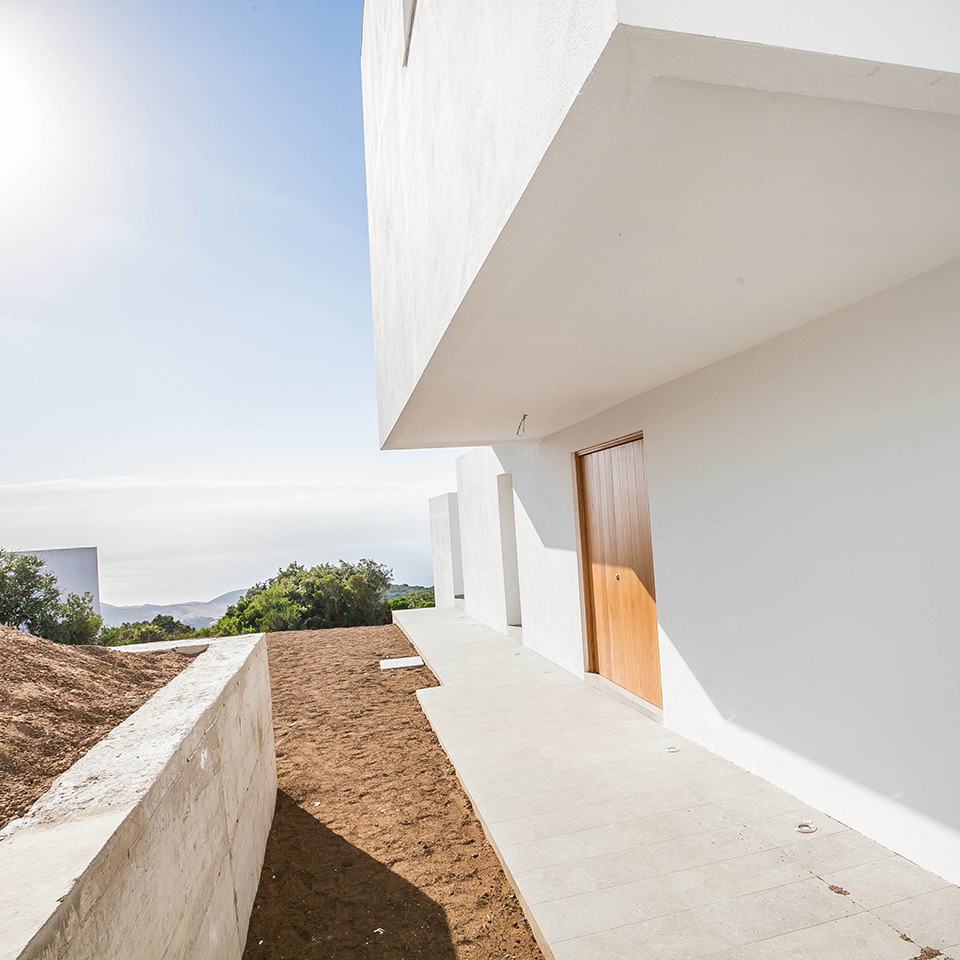 Backyard of white detached house with right angles
