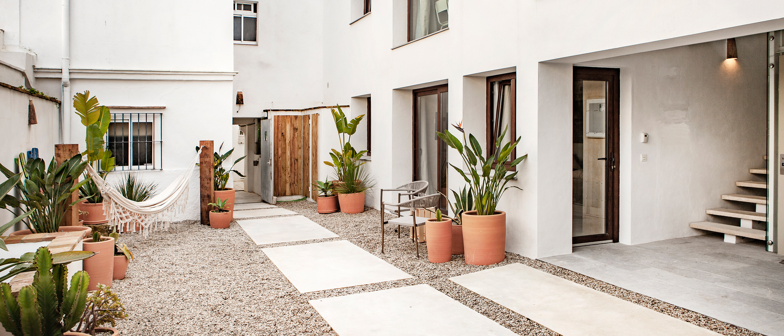 Patio interior de casa mediterránea con paredes blancas y plantas