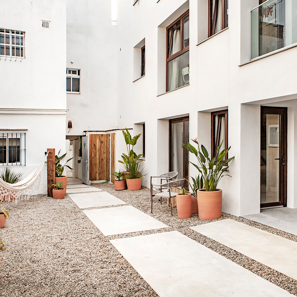 Patio interior de casa mediterránea con paredes blancas y plantas