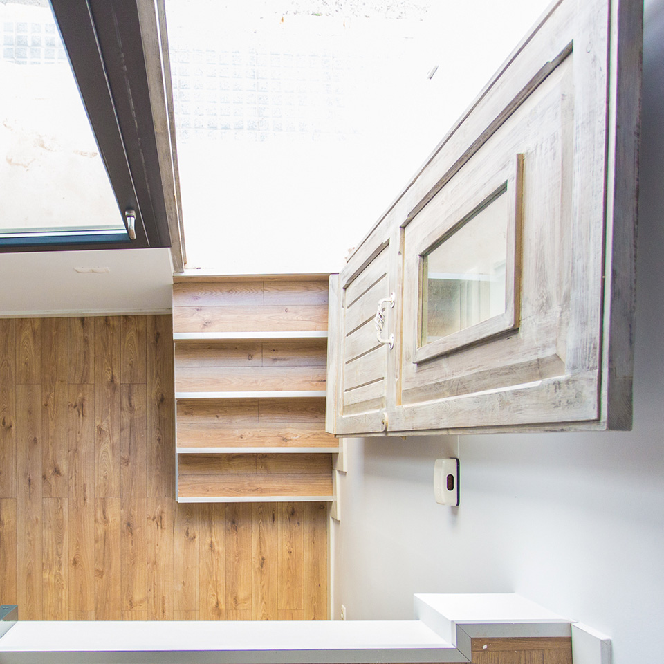 Vista cenital de escaleras de madera de entrada con puerta abierta y envejecida