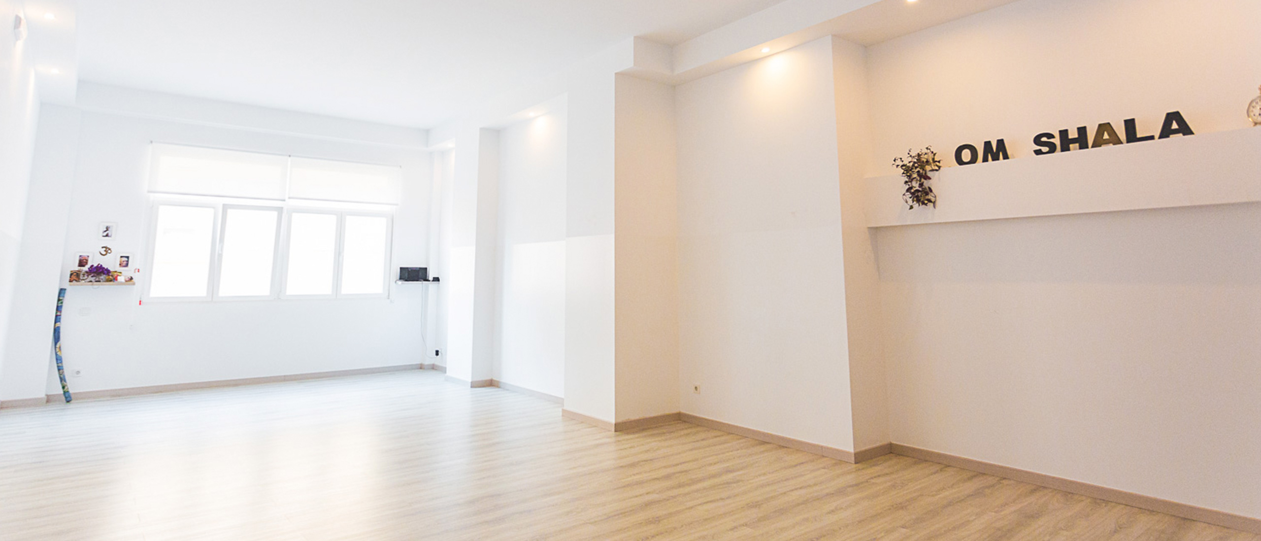 Sala blanca con ventanal y tarima de madera color marrón suave