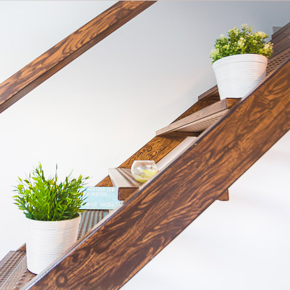 Escalera de madera oscura con dos tiestos blancos con plantas