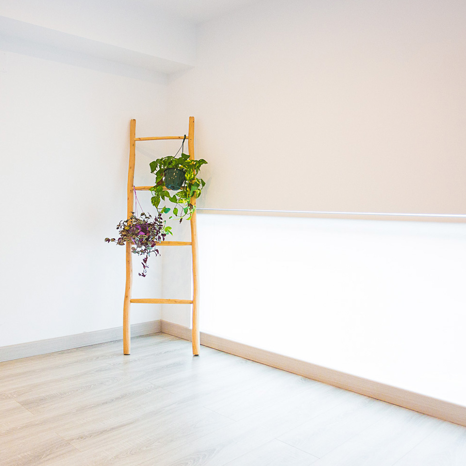 Sala blanca con tarima de madera color marrón suave y armario con accesorios para el yoga