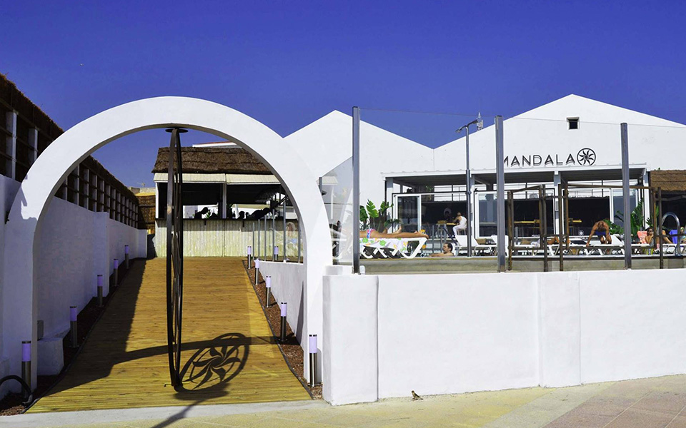 Entrada al Mandala Beach Club con puerta de metal con diseño de mandala