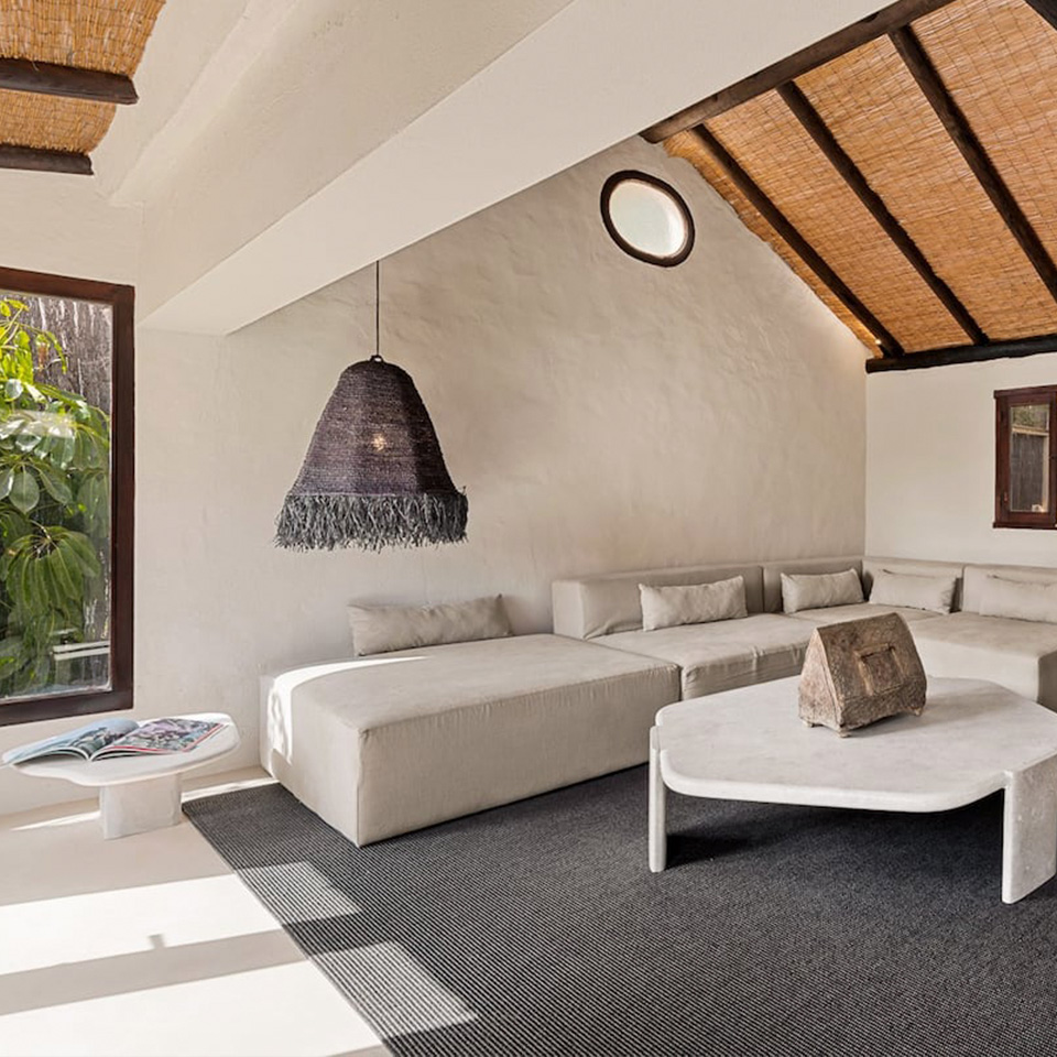 Salón con sofá gris y techos con vigas de madera con brezo