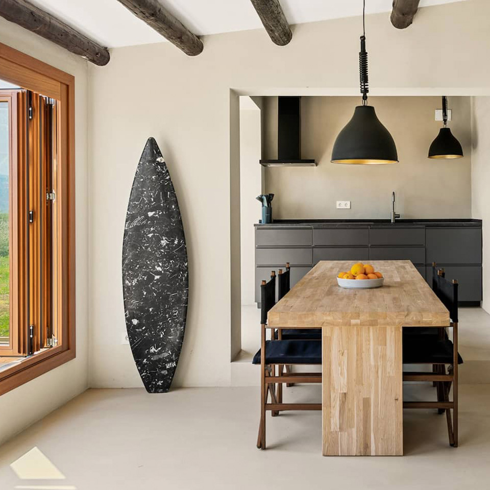 Mesa de comedor de madera con cocina abierta al fondo