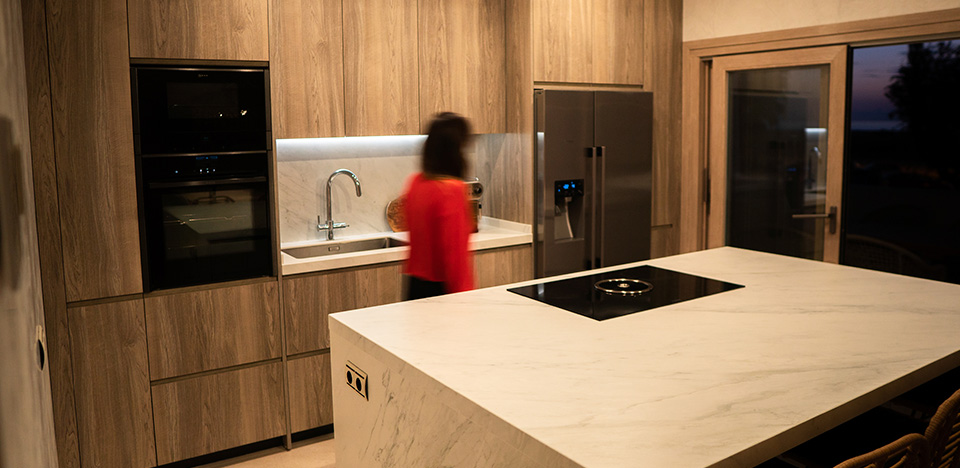 Cocina de muebles de madera con barra mesa americana