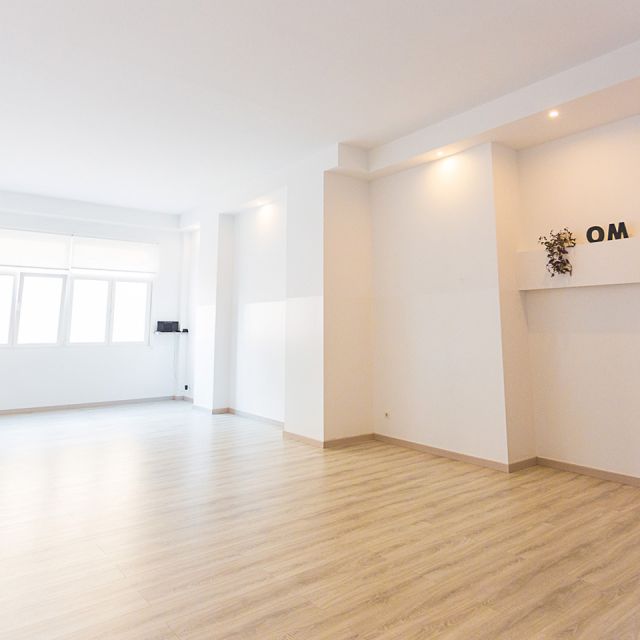Sala blanca con ventanal y tarima de madera color marrón suave